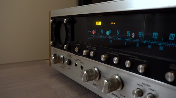 Premendo pulsanti e ruotando manopole su un vecchio amplificatore.