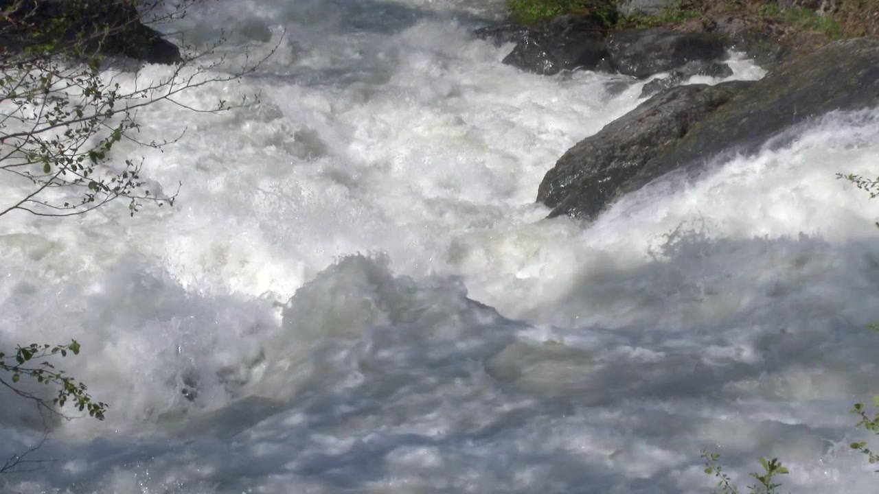 Powerful Rushing Water Flowing Over Rocks in a River