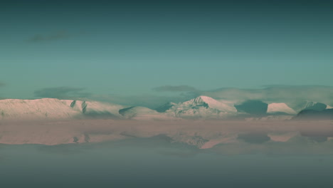 besneeuwde bergen weerspiegelen in mistig water, kust van reykjavik, timelapse