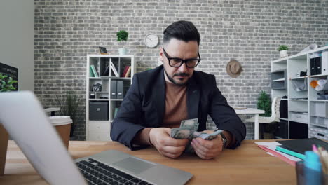 businessman counting money in office