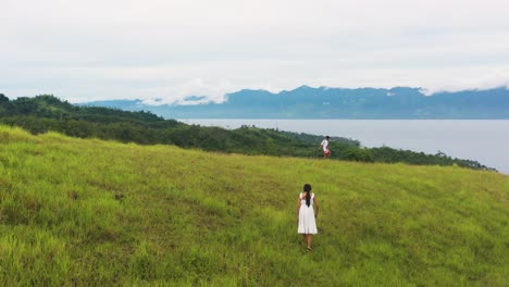 people walking across the rolling hills in tomas oppus, southern leyte, philippines