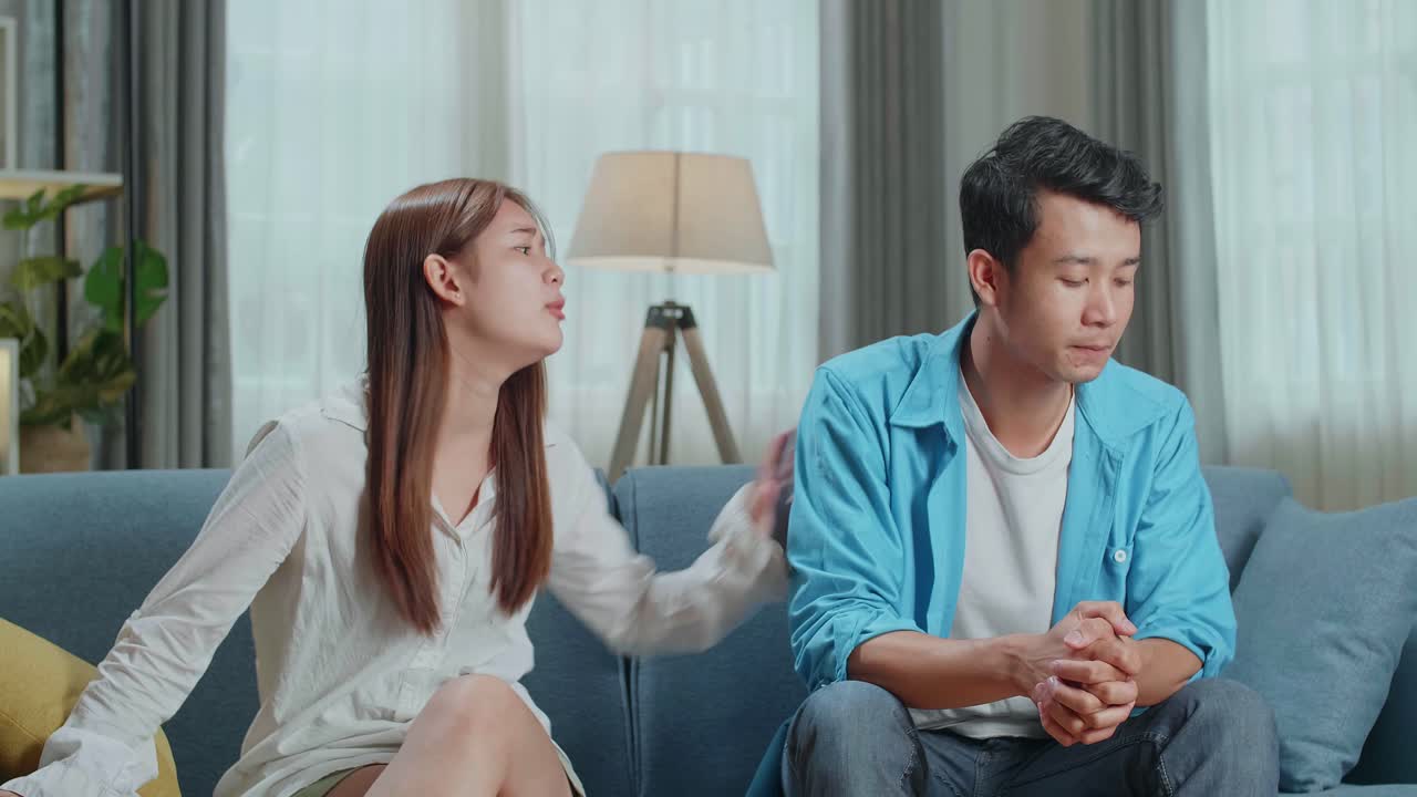 Couple Arguing. Angry Young Asian Woman Blaming Her Husband In The Living Room At Home