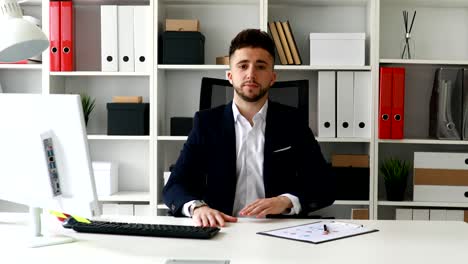 joven empresario haciendo un gesto con el dedo y mirando a la cámara