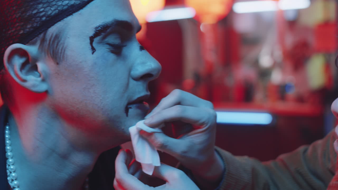 mujer limpiando la sangre de la cara de un amigo transgénero en un bar