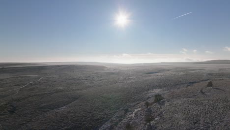 Drohnenaufnahmen-Fliegen-über-Wunderschöne,-Winterliche,-Gefrorene-Moorlandschaften,-Die-Von-Einer-Tiefstehenden-Sonne-Am-Blauen-Himmel-Beleuchtet-Werden