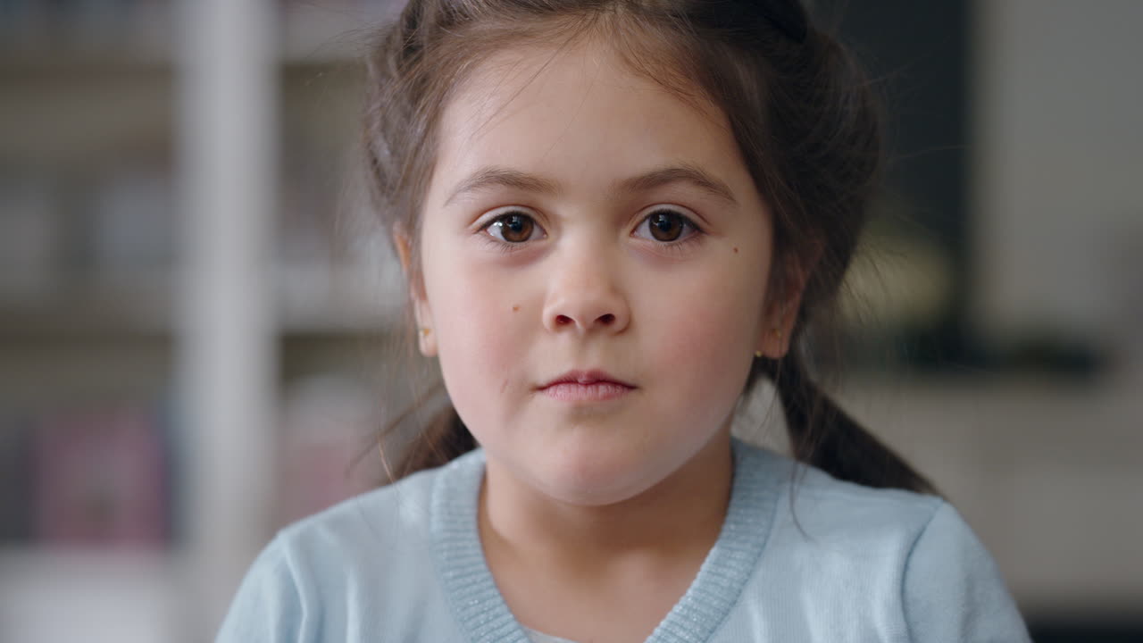 카메라를 바라보는 아름다운 어린 소녀의 초상화, 진지한 표정을 가진 귀여운 아이가 행복한 어린 시절을 즐기고 4k