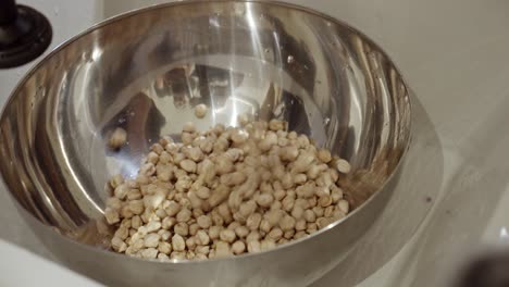 poner agua en un recipiente de metal lleno de garbanzos para remojar