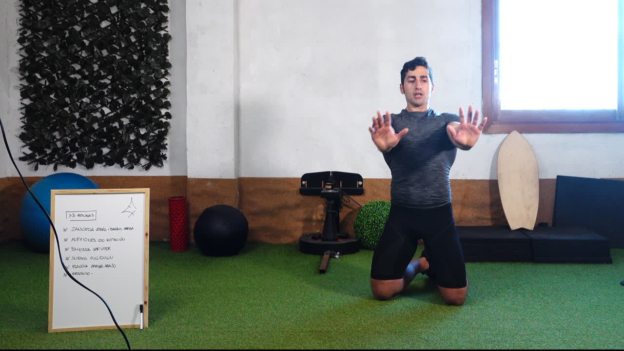 entrenador explicando la técnica para hacer felxions durante la clase de ejercicio en línea