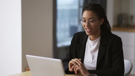 Mujer-De-Negocios-Negra-Sentada-En-La-Mesa-En-La-Oficina-Usando-Una-Computadora-Portátil-Por-Videollamada