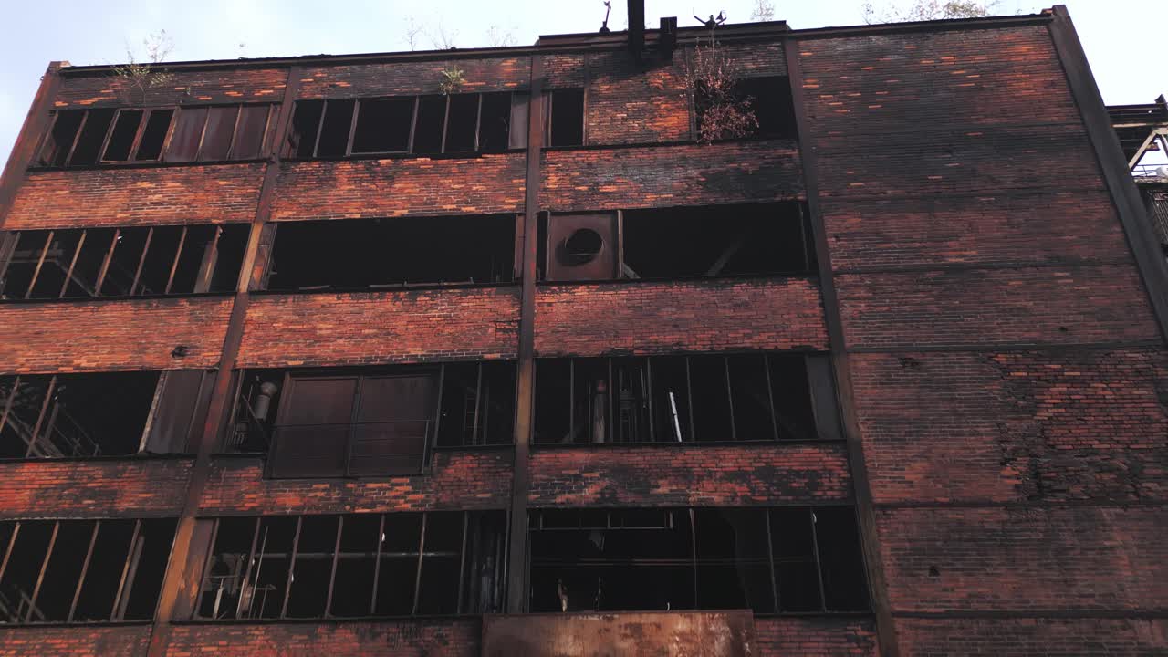 Old abandoned, industrial building with broken windows and a rusted exterior