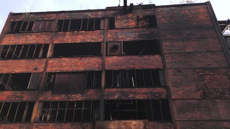 old abandoned, industrial building with broken windows and a rusted exterior