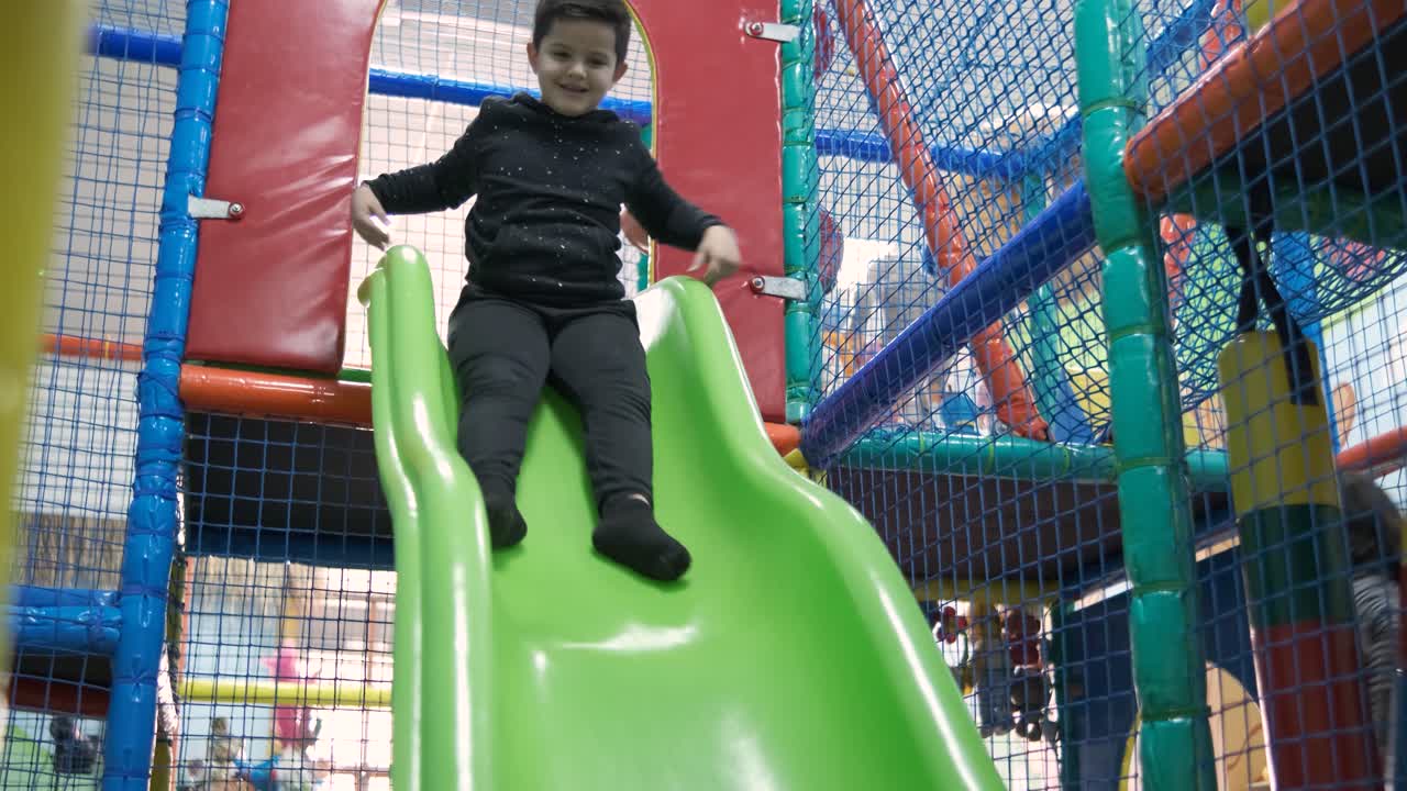 Little boy riding on slide in entertainment center