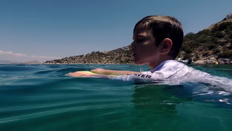 Caucasian-kid-swimming-at-sea-of-Sofiko,-Corinth,-Greece