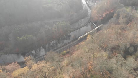 Aerial-view-high-speed-train-passing-through-autumn-landscape,-Sweden