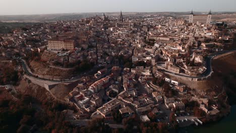a backward drone shot of toledo and its cathedral at sunset