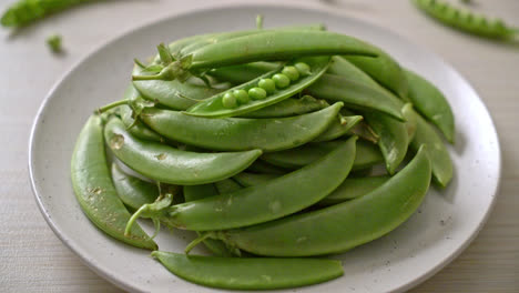 fresh sweet green peas on white plate