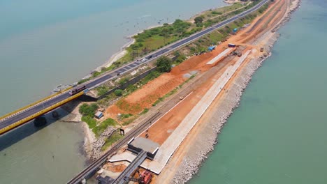 aerial drone shot capturing the harmonious blend of rameshwaram’s cityscape and its famous bridge.