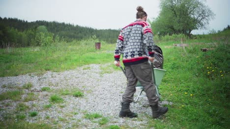 Norwegian-Man-Pushes-Wheelbarrow-Loaded-With-Bag-Of-Garbage