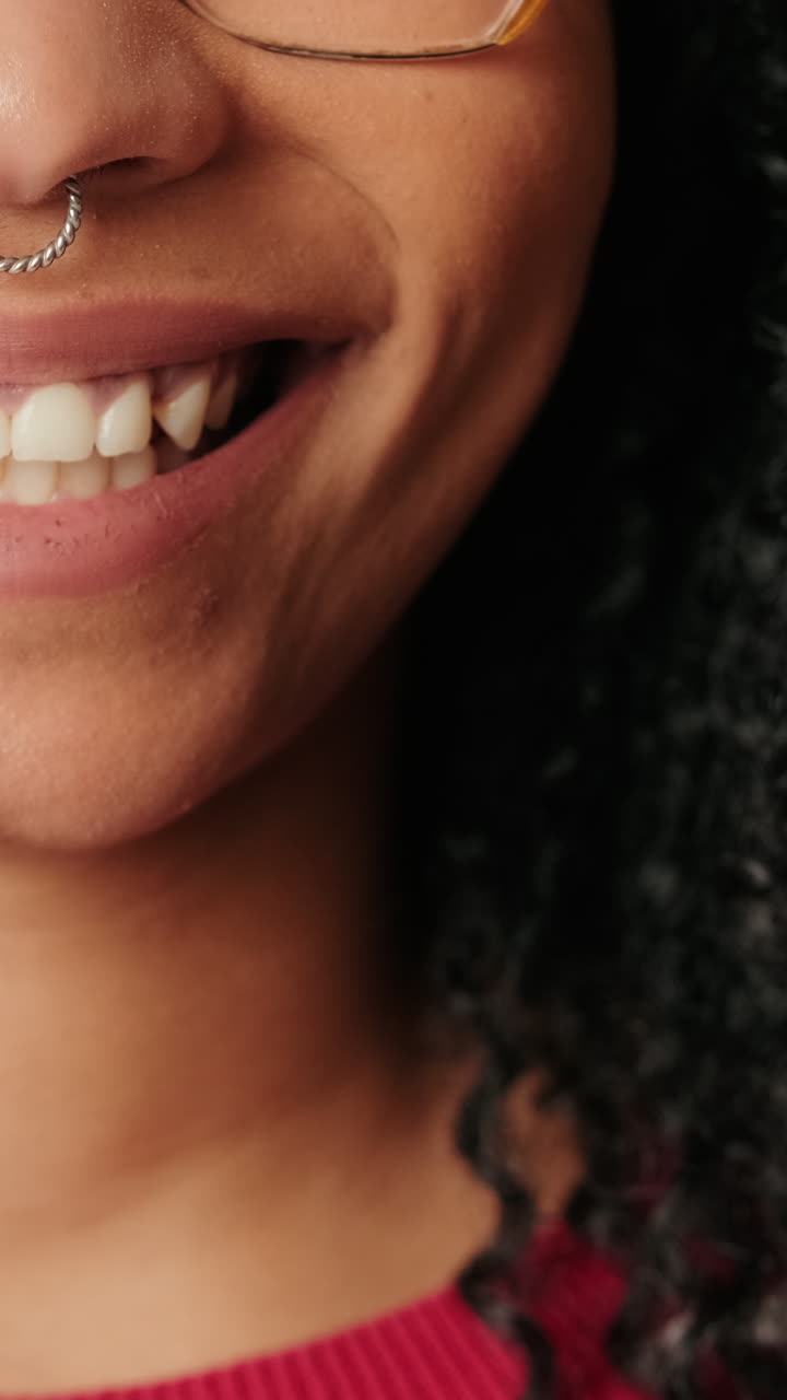 Close-Up of a Smiling Woman with Glasses and Septum Piercing