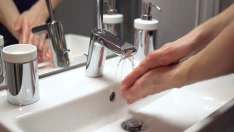 Close-up-of-person-washing-hands-in-clean-bathroom