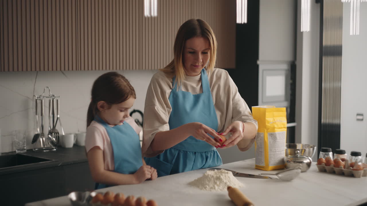 mujer y su hija están cocinando masa para pastel o pastel de cerca de las manos y la harina en la mesa
