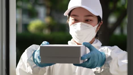 a young woman in a white outfit and mask engaged in an activity at a doorway, highlighting safety and care in daily life amidst health concerns