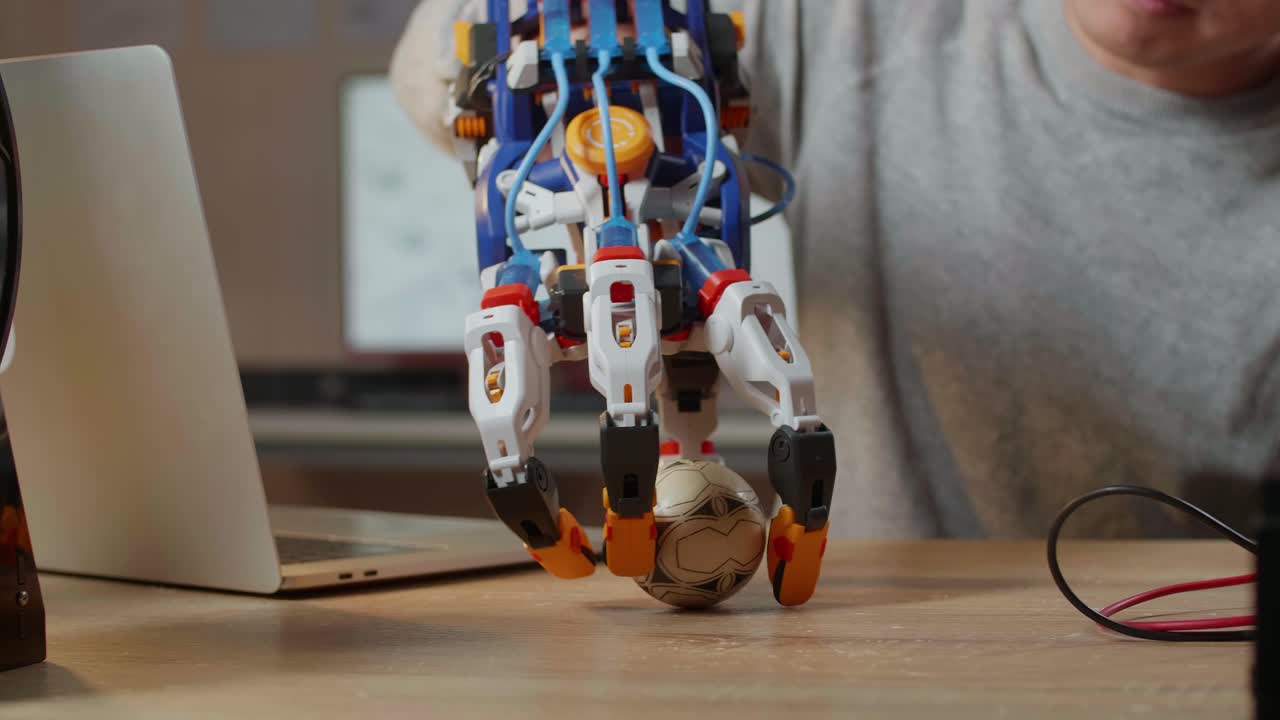 brazo robótico sosteniendo una pelota de fútbol