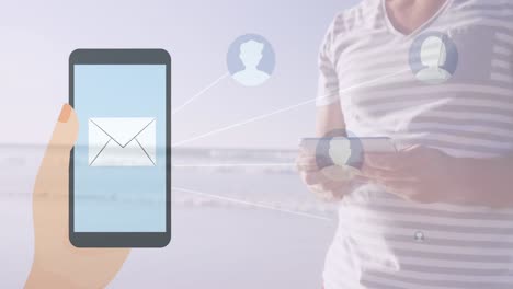 Network of connections over hand holding smartphone icon against man using smartphone at beach