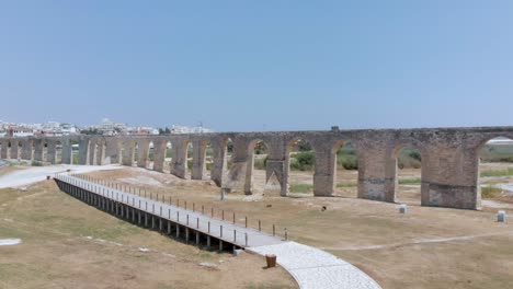 amplia toma de drones volando sobre los arcos del acueducto de kamares para revelar complejos turísticos y edificios locales