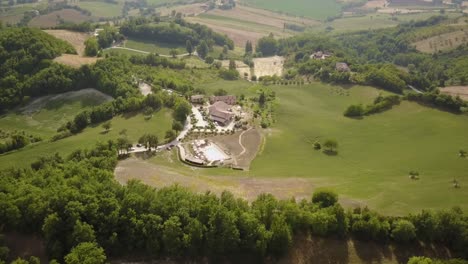 view of the italian countryside with a big house and a pool