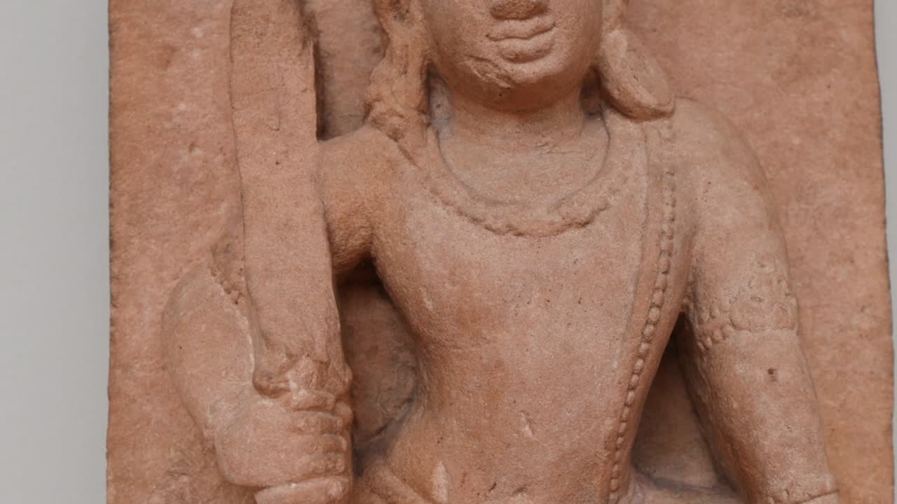 Vista dettagliata di un'incisione rupestre che mostra una figura con gioielli ornati e un bastone
