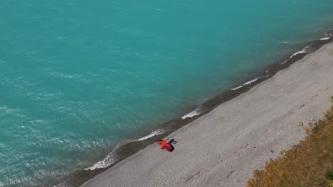 vista aérea de drones - equipo de surf de lámina de ala en la orilla del lago, agua azul brillante