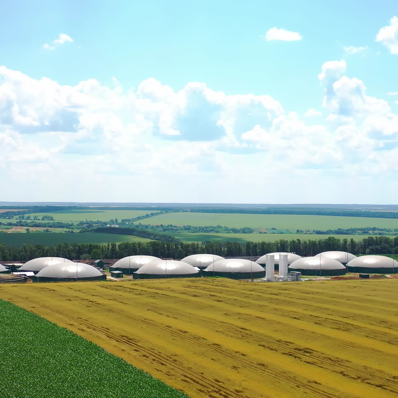 New plant for biogas technologies on field. Modern reservoirs for renewable energy on green nature background. Aerial view