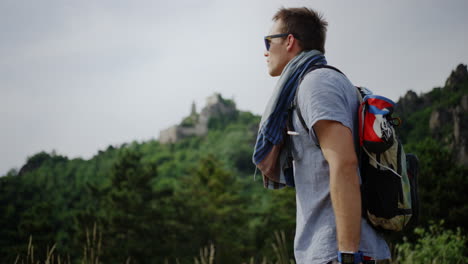 hombre mirando sobre el paisaje verde de la montaña, burgruine dürnstein castillo en el fondo, sendero de senderismo, colinas valle, caminata ruta de senderismo austria ruta de caminata al aire libre, persona masculina tomando un descanso, descanso