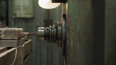 metal part machining on industrial lathe with close-up on spinning chuck and tool