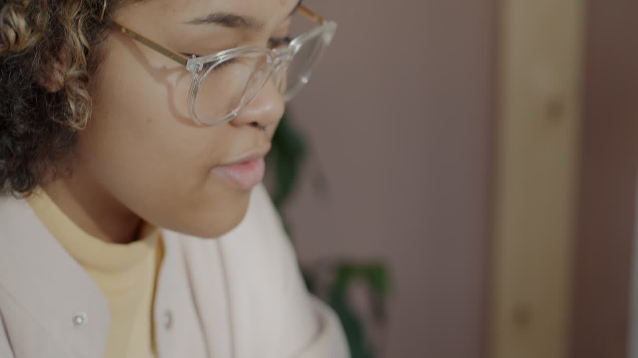 Close-up of a woman with curly hair and glasses