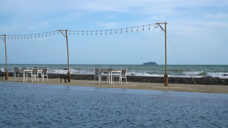 dinning table near swimming pool with sea background