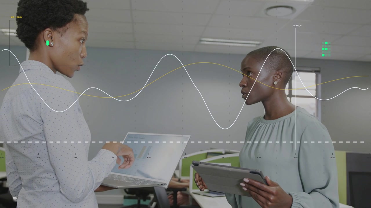 Two women coworkers presenting laptop charts, analyzing business data, waveform highlighting trends