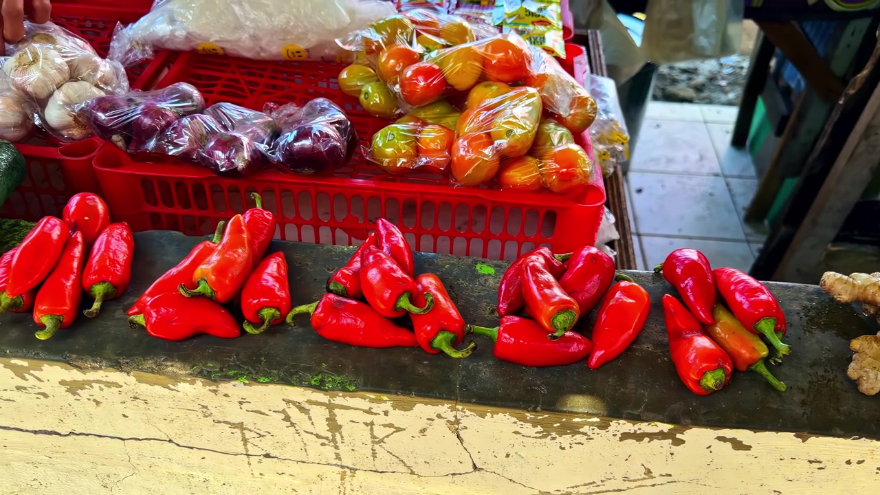 Surtido colorido de chiles rojos y otros productos frescos exhibidos en un puesto de mercado al aire libre en Surigao, Filipinas