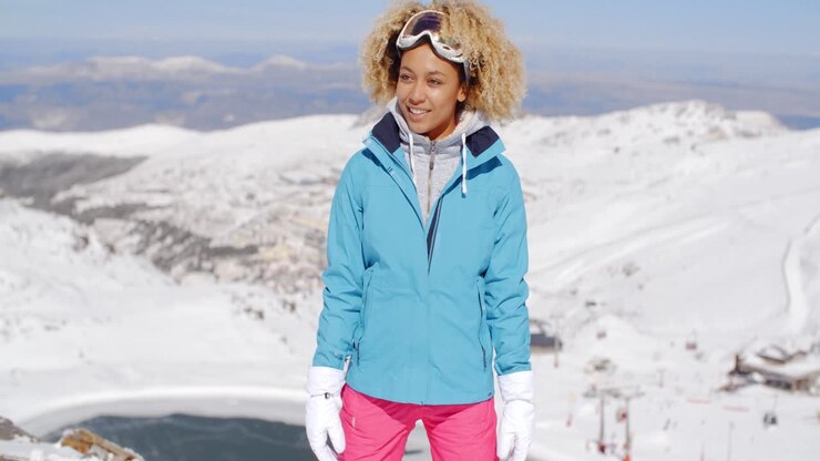 Beautiful woman in ski outfit standing on mountain