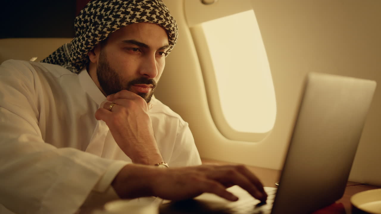Thoughtful muslim working laptop on business trip closeup. Rich man typing