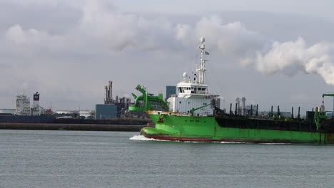 Ship-moving-up-the-waterway-with-industrial-docks-in-the-background