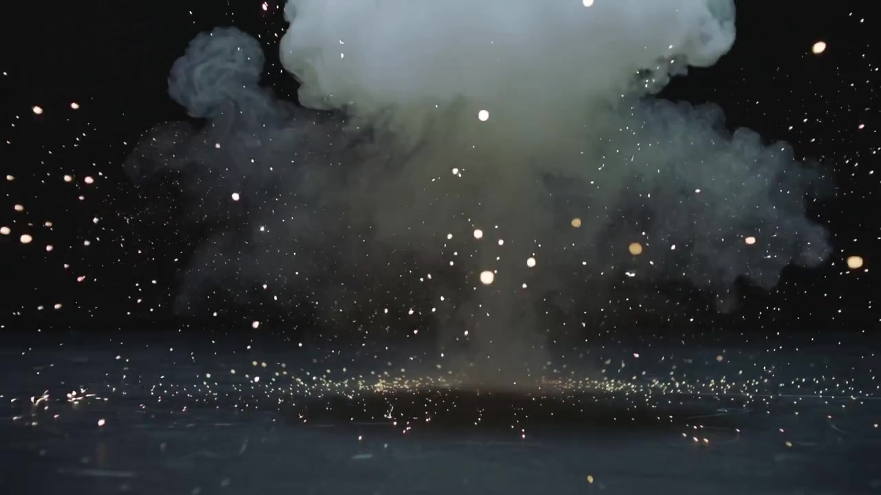 Accensione di una piccola carica pirotecnica che forma una nuvola a fungo su un pavimento lucido, emettendo scintille e braci luminose.