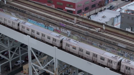 vista aérea del metro en una vía ferroviaria elevada en brooklyn, tomada en un día nublado en gowanus.