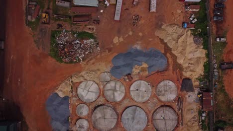 top down aerial of an industrial lot with sand piles and junkyards in nigeria, africa