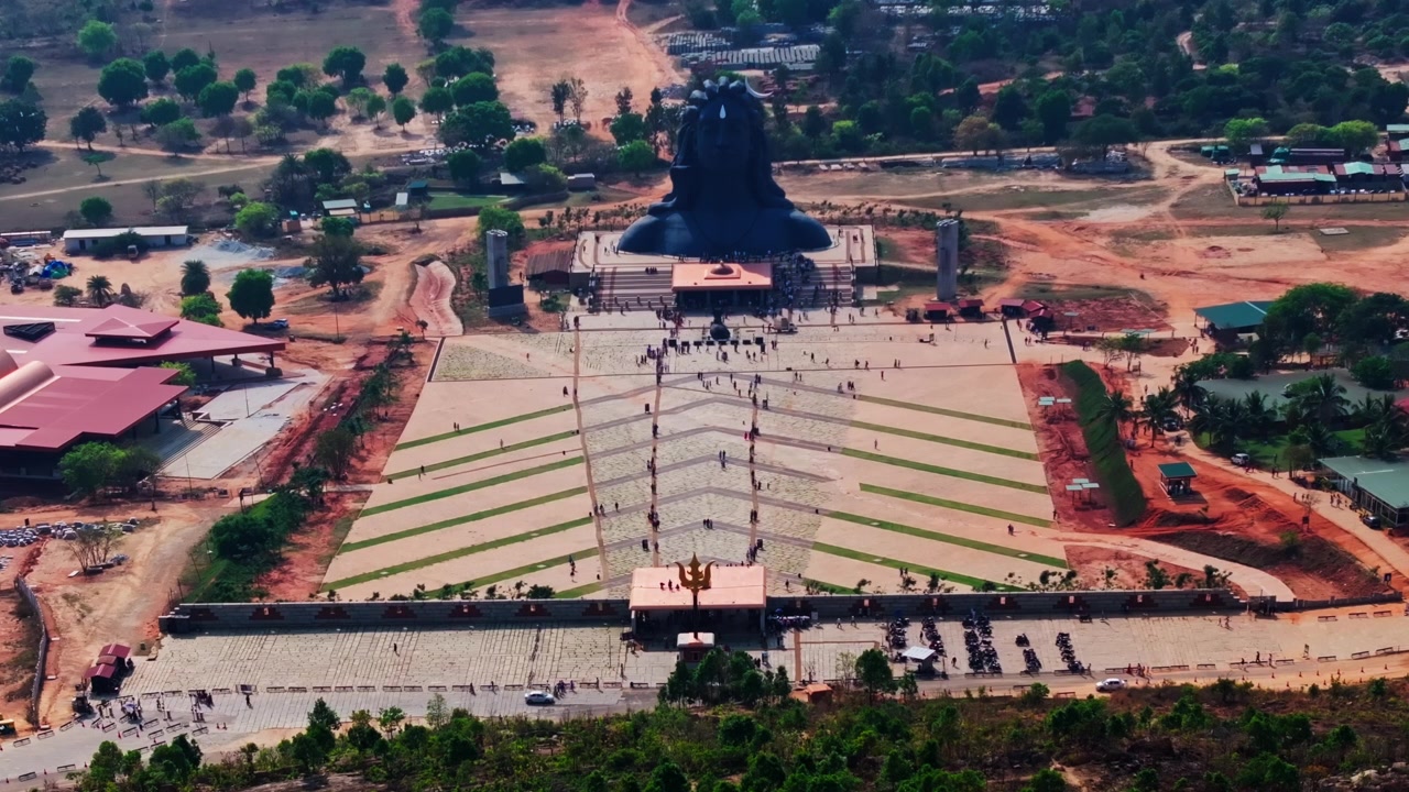 Vista aerea della statua di Adiyogi Shiva con Trishula, turisti e Shri Naagara Mantapa presso la Isha Foundation, Chikkaballapura, Bangalore, Karnataka, India. Di giorno, inquadratura stabile, ripresa con drone, 4K.