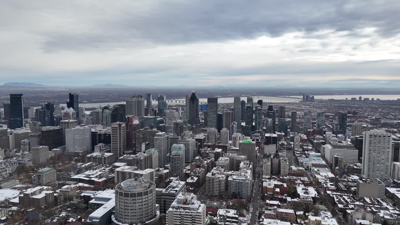 Aerial view of Montreal's snowy cityscape with modern skyscrapers and a cloudy sky, perfect for travel and business-related projects, Canada