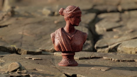 ancient statue of woman on rocky stones