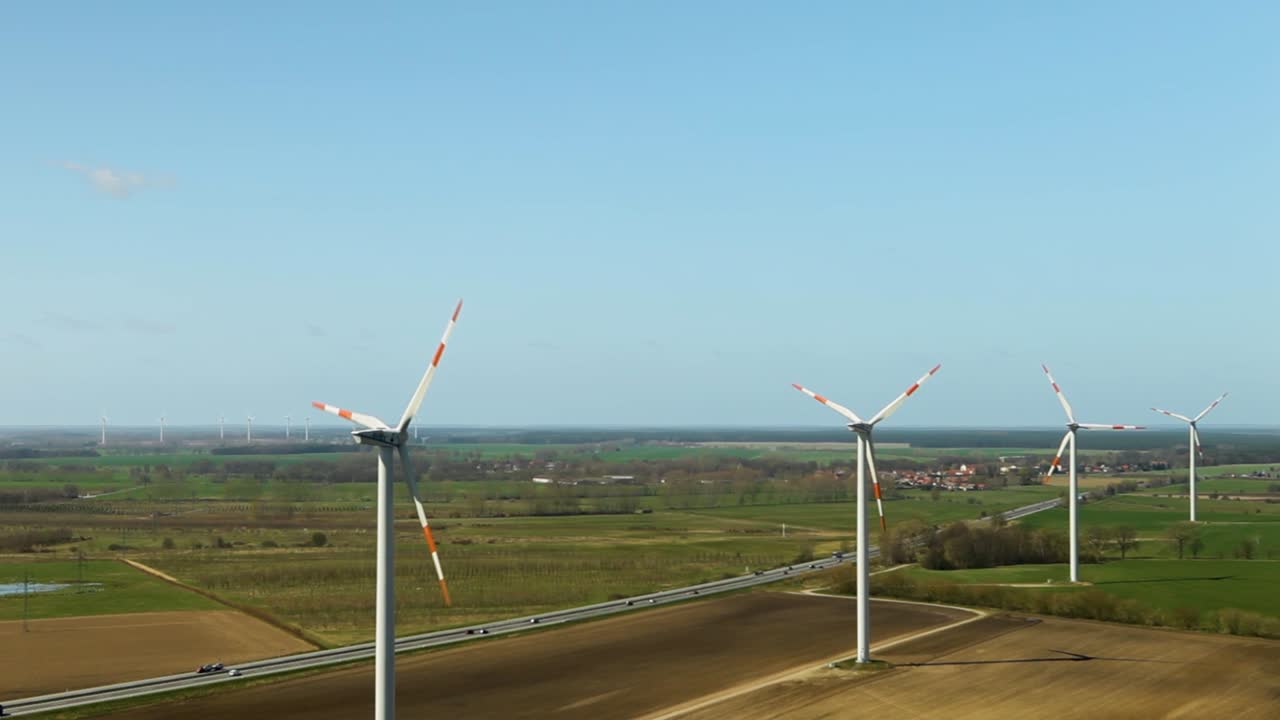 풍력 터빈은 이 좋은 날에 울창한 농경지 위에서 부드럽게 회전하여 지속 가능한 에너지를 보여줍니다.