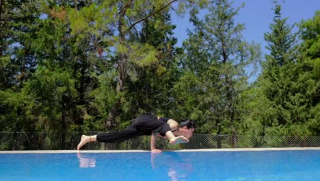 woman doing yoga by the pool